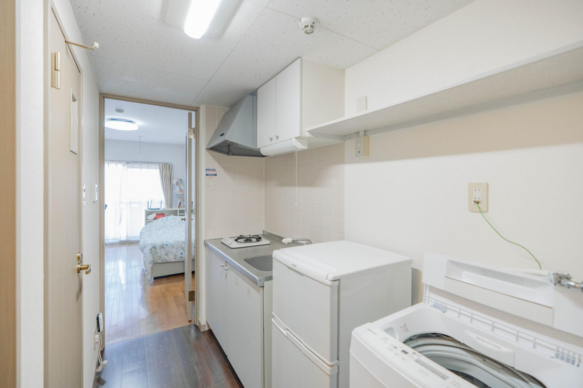 居室内のミニキッチンと洗濯機。