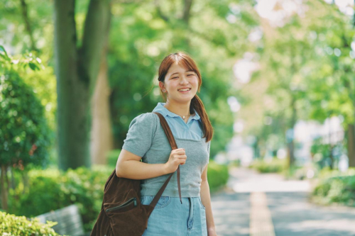 船堀の緑道でリュックを背負い笑顔を見せるTさん