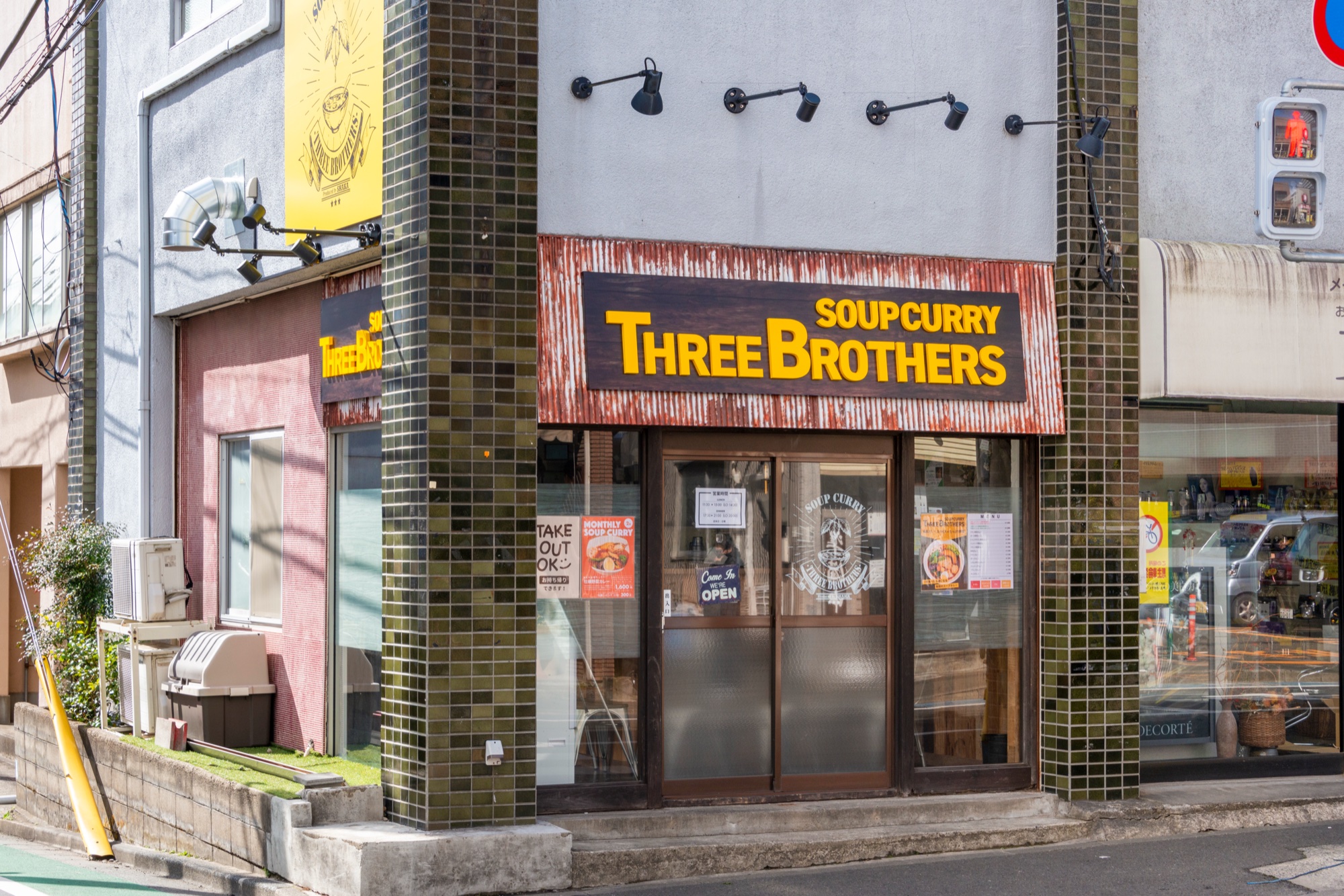 SOUP CURRY THREE BROTHERSの黄色いロゴが目を引く外観